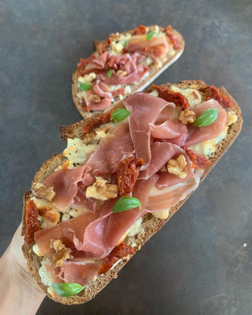 Toasts au chèvre, miel, jambon cru, tomate séchée et noix