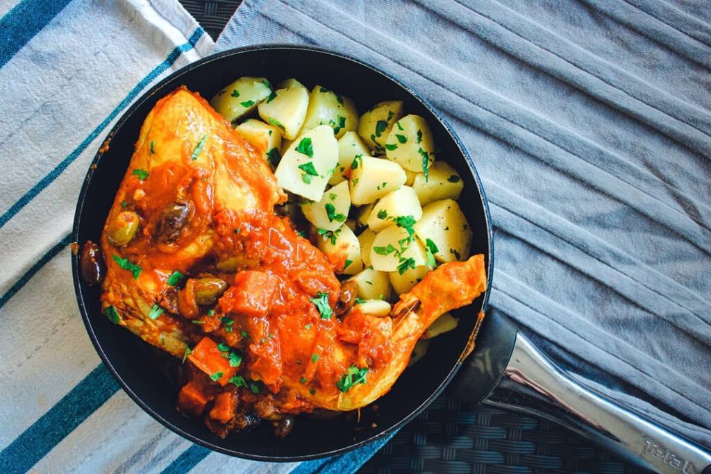 Tajine de poulet aux olives et poivrons rouges, pommes de terres au persil et oignons confits