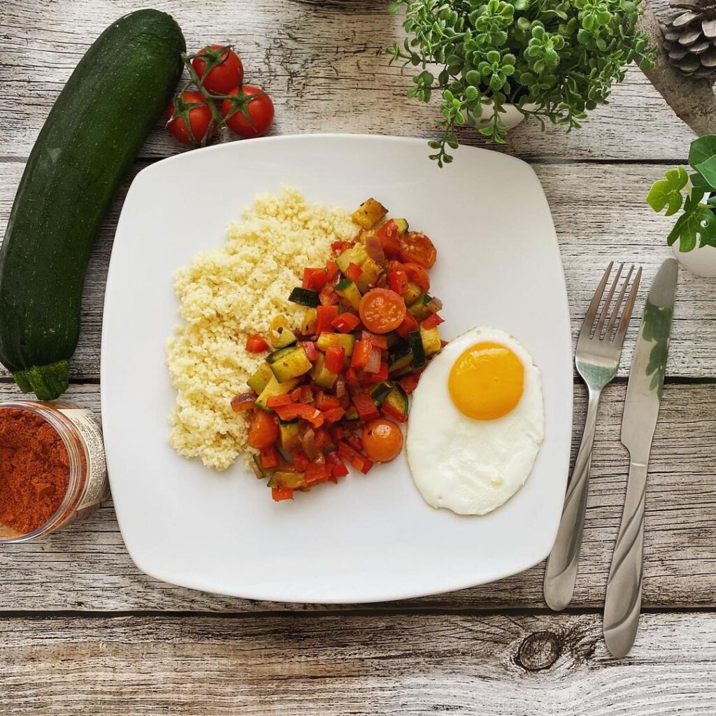 Semoule aux légumes d’été épicés et œufs sur le plat