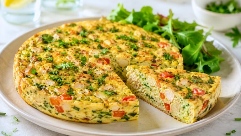 Quiche sans pâte au poulet, tomates et courgette, servie froide avec une salade verte